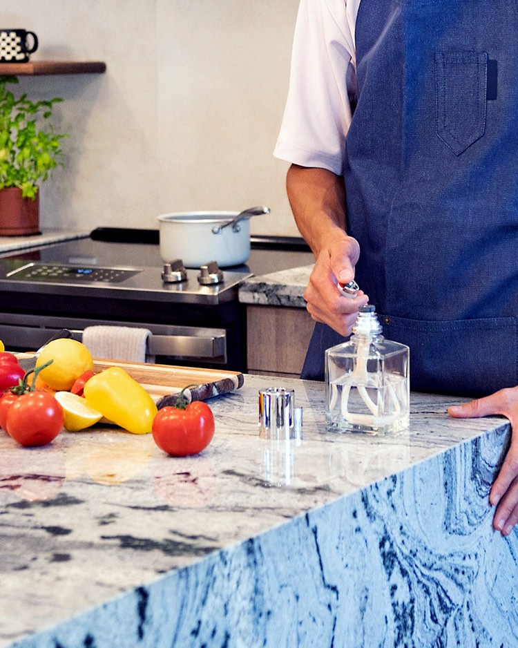 Lighting A Lampe Berger Fragrance Lamp While Cooking